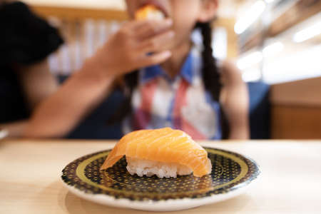 A child eating salmon sushiの写真素材