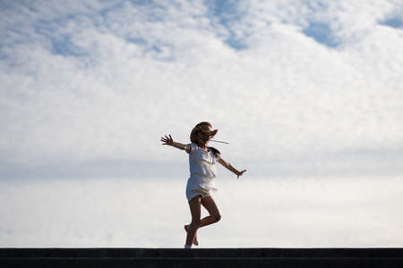 Girl playing under the blue skyの写真素材