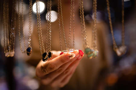 Women's hands choosing accessories at the storeの写真素材