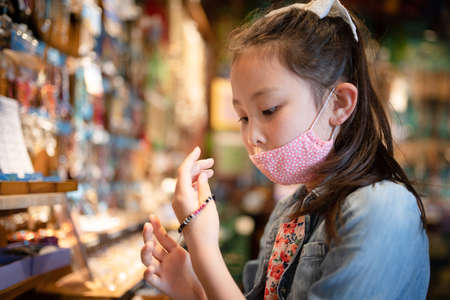 Girl wearing a mask enjoying shoppingの写真素材