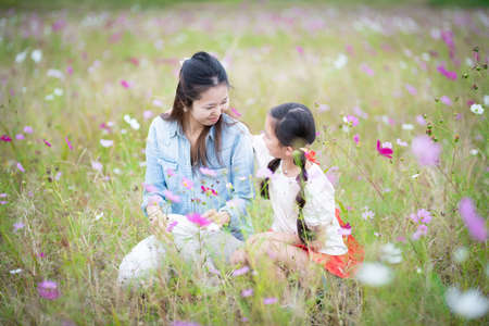 Mother and daughter playing in a flower fieldの写真素材