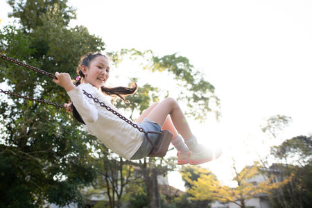 Girl playing on a swingの写真素材