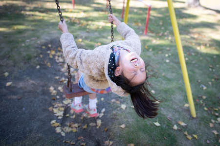 Smile girl playing on a swingの写真素材