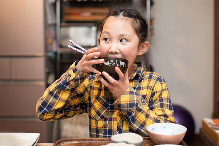 A girl drinking miso soupの写真素材