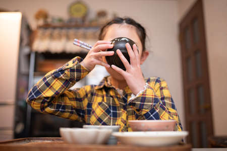 A girl drinking miso soupの写真素材