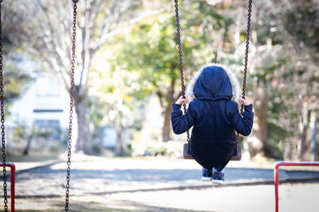 Back view of a child on a swingの写真素材