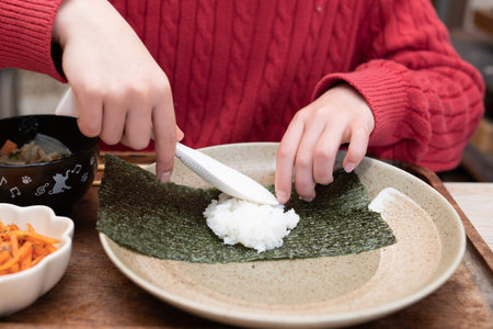 A child who makes hand rolled sushiの写真素材