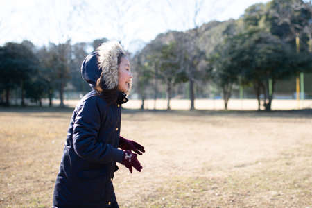 Girl playing in the winter parkの写真素材