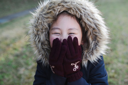 Girl blowing on her cold hands