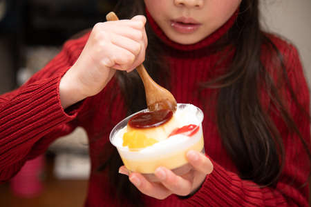 Girl eating puddingの写真素材