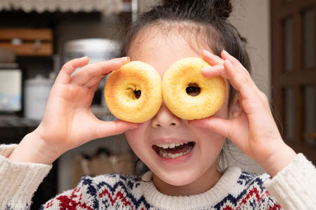 Girl peeking through a hole in a donutの写真素材