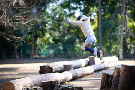 A child jumping in a forest parkの写真素材