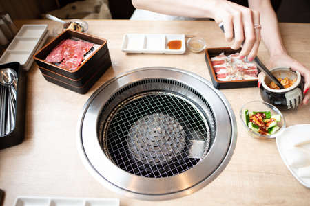 A woman eating at a Japanese yakiniku restaurantの写真素材