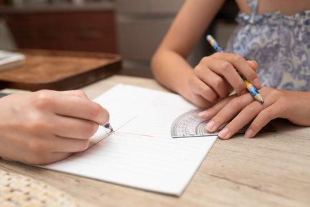 Hands of a child who is taught to study