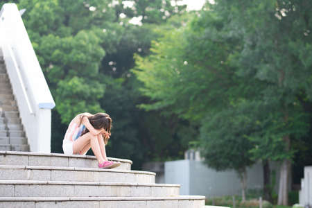 girl sitting on stairs and cryingの写真素材