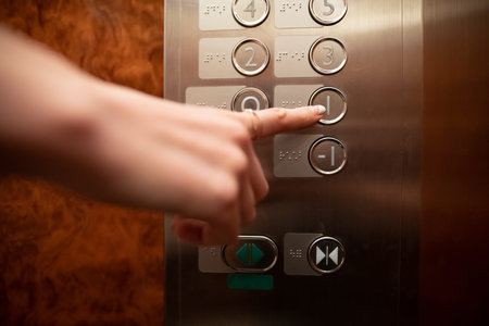 Woman's hand operating old elevator buttons