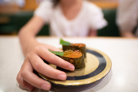 A child who eats salmon roe sushiの写真素材