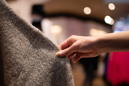 Woman's hand choosing a sweaterの写真素材