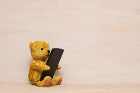 teddy bear looking at smartphoneの写真素材