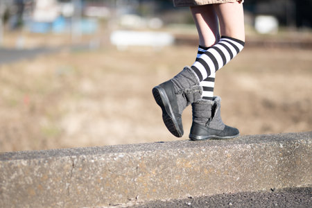 A child wearing boots walksの写真素材