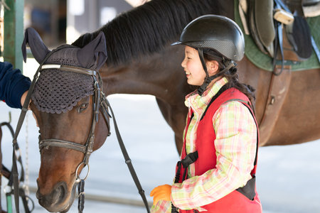 Girl learning to ride a horseの写真素材