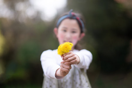 Girl holding out a dandelion