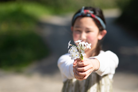 girl holding out white flowersの写真素材