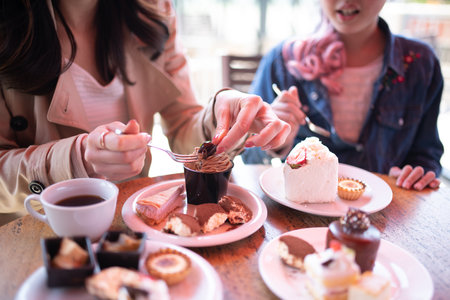 Mother and daughter eating a lot of sweetsの写真素材