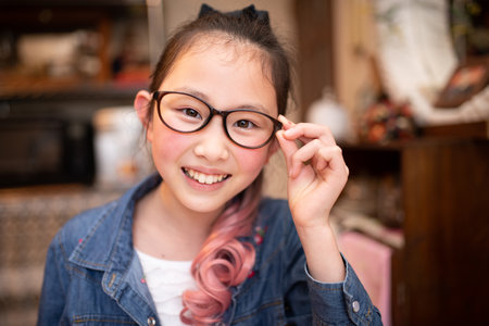 Girl with pink hair wearing glasses smilesの写真素材