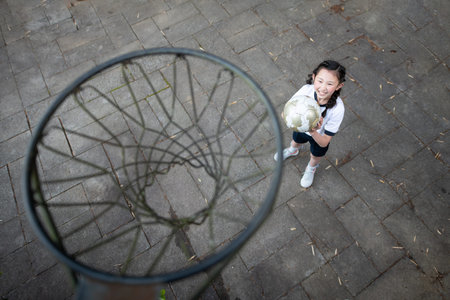 Child in gym clothes playing basketball