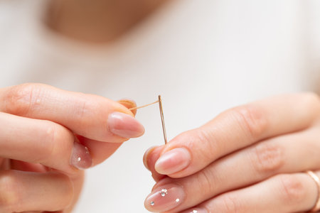 Woman's hand threading a needleの写真素材