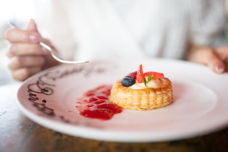Delicious tartlet with berries and jam on a plate in a restaurantの写真素材