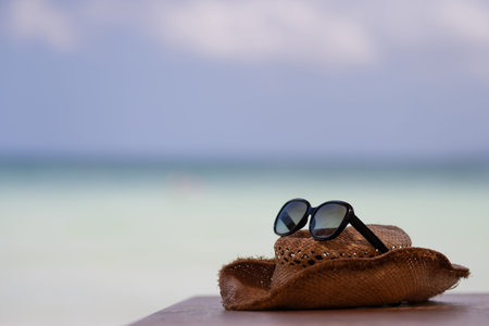 Straw hat and sunglasses placed on the beach