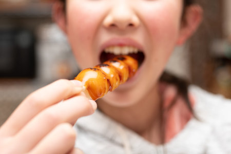 Child eating Japanese mitarashi dangoの写真素材