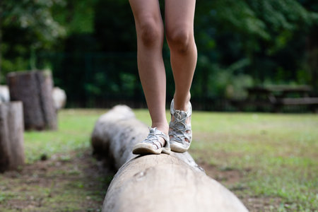 Close up of legs of a girl walking on a log in the parkの写真素材