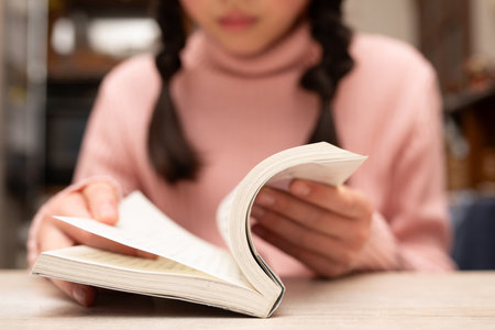 Woman reading book at table in cafe, closeup. Reading conceptの写真素材