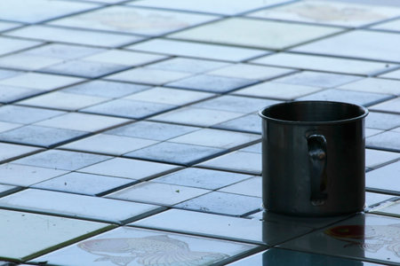 Stainless steel mug on tile floor.