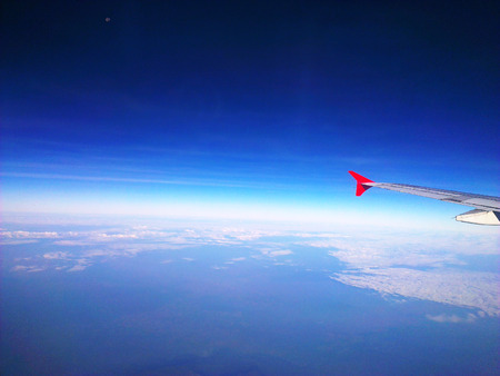 Aircraft Wing and the sky above the cloudsの写真素材