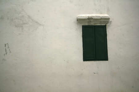 White cement wall with green window.の写真素材
