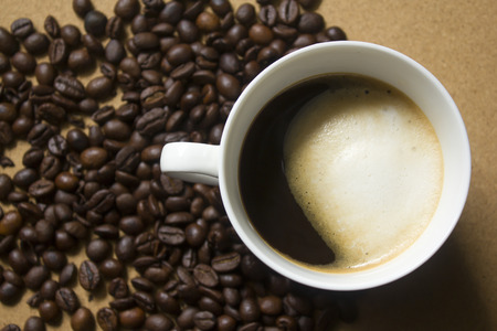 Milk froth in coffee mugs and coffee beansの写真素材