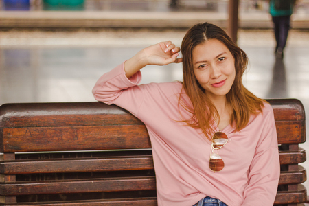 Woman sitting in a chair in a train stationの写真素材