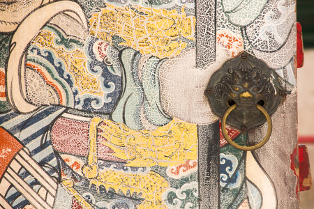 The lion-shaped door handle is on the old wooden door.の写真素材