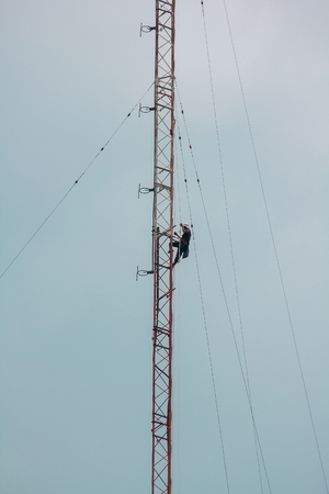Men are climbing on the antenna. To install the deviceの写真素材