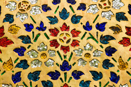 Multi-colored glass decorated on the wall of the temple in Thailand.