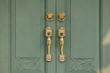 Door Handles Old brass on the green door Used to close or open the doorの写真素材