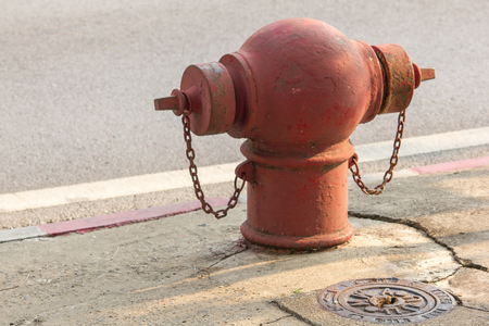 Fire extinguisher is located on the footpath of the road.の写真素材