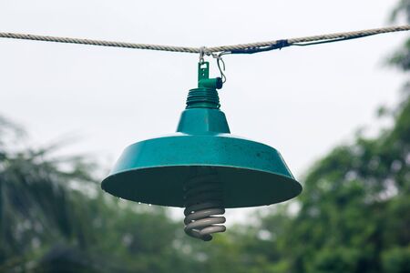 Old green lanterns hung with ropes and wet with rain.の写真素材