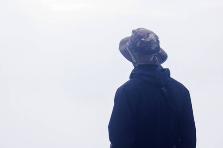 The black shirt men are watching the fog on the mountain.の写真素材