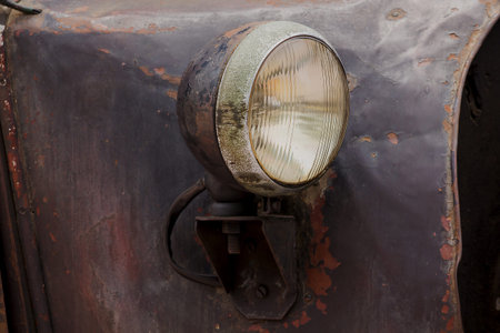 Lights in front of a vintage car with a unique sphere.