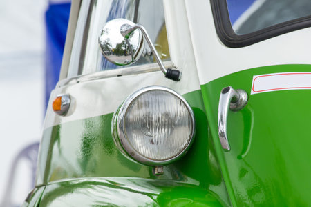 Lights in front of a vintage car with a unique sphere.